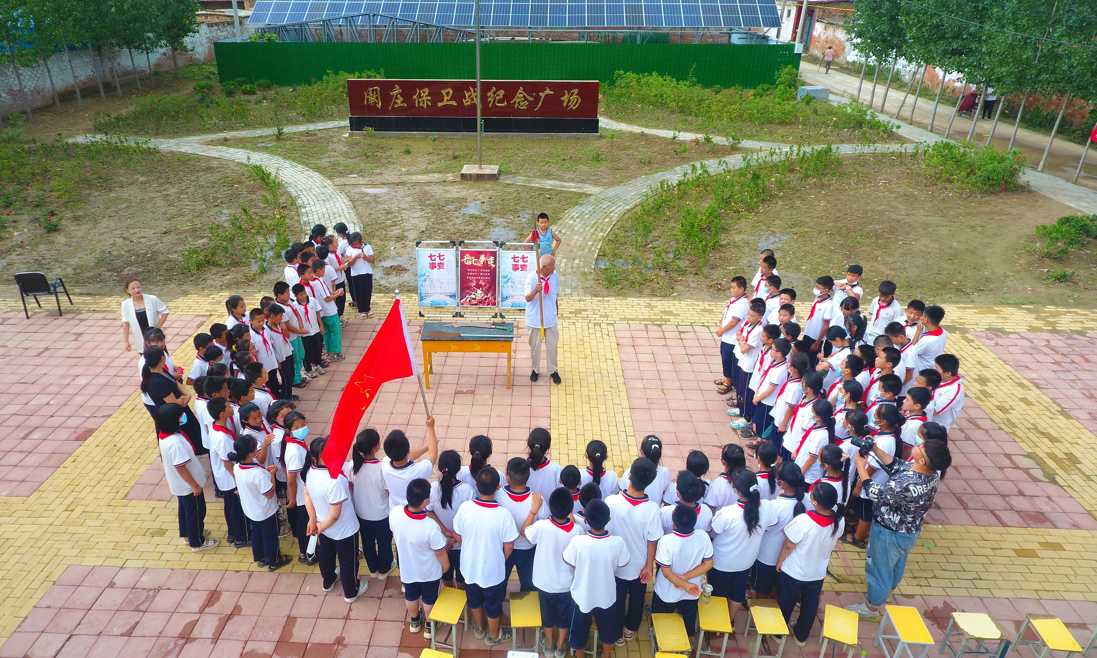 2022年7月6日，山東省聊城市，在茌平區(qū)菜屯鎮(zhèn)闞莊村的闞莊保衛(wèi)戰(zhàn)紀(jì)念廣場，闞莊保衛(wèi)戰(zhàn)親歷者王光木老人，為小學(xué)生們講述抗戰(zhàn)故事，展示大刀、長矛。